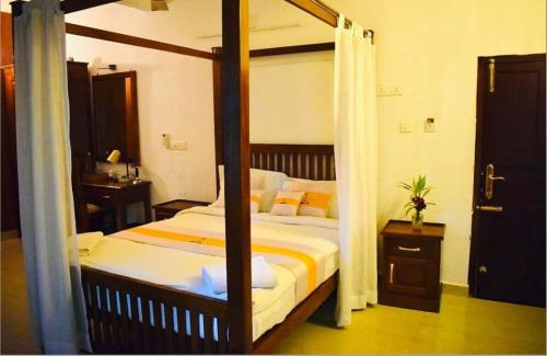a bedroom with a four poster bed in a room at The Boho Inn in Cochin