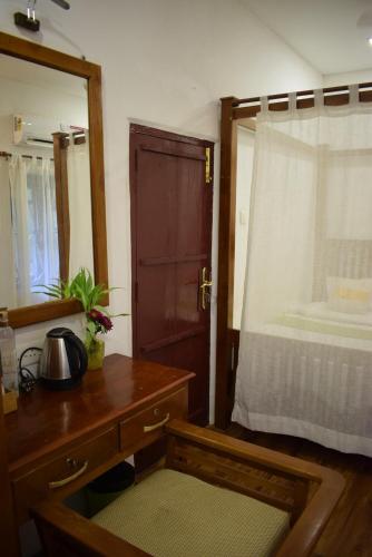 a bedroom with a dresser and a mirror and a bed at The Boho Inn in Cochin