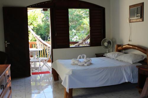 een slaapkamer met een bed met twee knuffels erop bij Casa Atalaia in Pipa