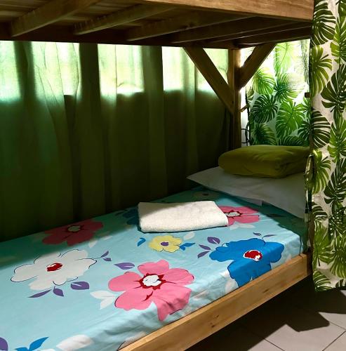 a bed with flowers on it in a room at Amancio's Tourist Inn-Close to the Airport in Puerto Princesa City