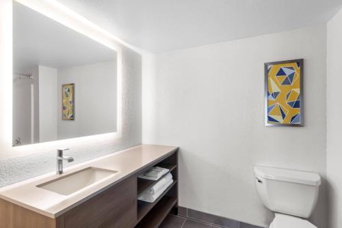 a bathroom with a sink and a toilet and a mirror at Comfort Suites Austin Airport in Austin
