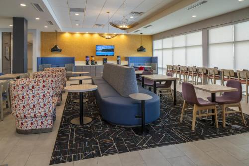 a waiting room with tables and chairs and a bar at Home2 Suites By Hilton Montgomery Downtown in Montgomery