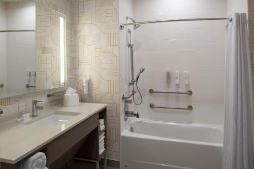 a white bathroom with a tub and a sink at Home2 Suites By Hilton Montgomery Downtown in Montgomery