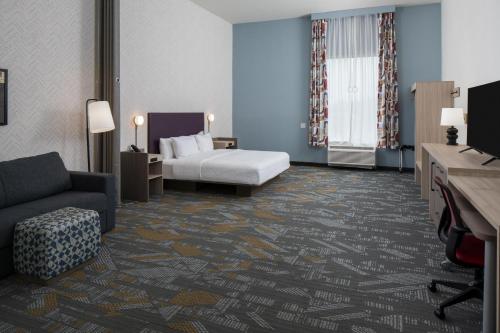a hotel room with a bed and a couch at Home2 Suites By Hilton Montgomery Downtown in Montgomery