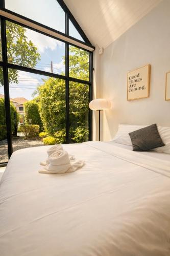 a bedroom with a large white bed with a large window at Pruksa Place Udon Thani in Udon Thani