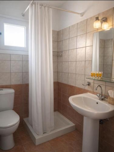 a bathroom with a white shower curtain and a sink at Rodanthy Studios IV in Katelios