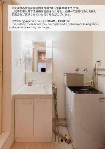a small bathroom with a sink and a refrigerator at Rafaye N16 in Sapporo