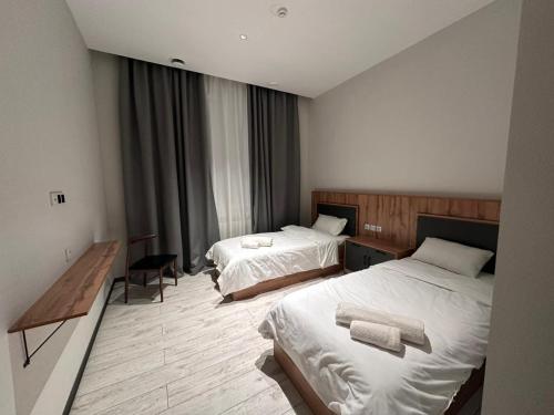 a hotel room with two beds with towels on them at Гостиница Ислам in Khromtaū