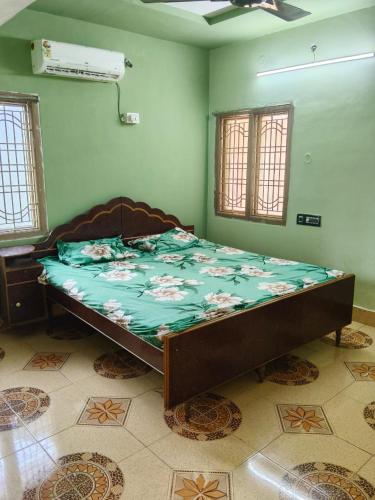 a bed in a room with a green wall at Sumathinandanakuteer in Pithāpuram