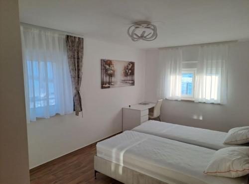 a bedroom with two beds and two windows at Apartment Freya in Zadoborje