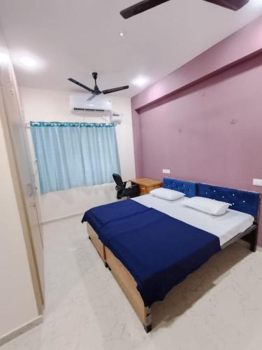 a bedroom with a blue bed and a ceiling fan at RV Comforts in Perambalūr