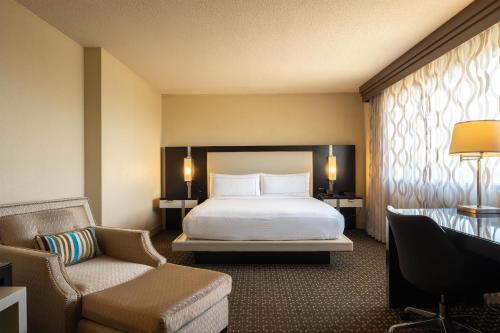 a hotel room with a bed and a chair at DoubleTree by Hilton Hotel Houston Hobby Airport in Houston