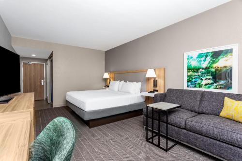a hotel room with a bed and a couch at Hampton Inn & Suites Port St. Lucie in Port Saint Lucie