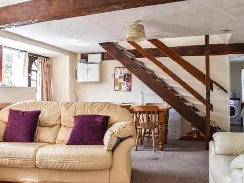 a living room with a couch and a table at Meadow Cottage in Leek
