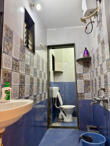 a blue and white bathroom with a toilet and a sink at The Calm Courtyard- Pune in Pune