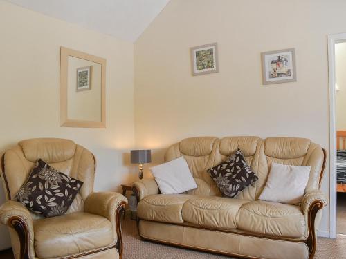 a living room with two chairs and a couch at Stable Cottage in Leek