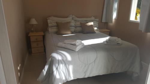 Un dormitorio con una cama blanca con toallas. en Magda en Villa La Angostura