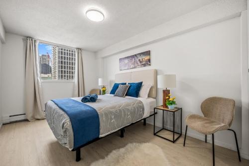 a bedroom with a bed and a chair and a window at 17th Ave Cozy Place in DT, short walk to Calgary Stampede in Calgary