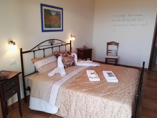 a bedroom with a bed with two stuffed animals on it at Agriturismo Agri Armonia in San Lucido