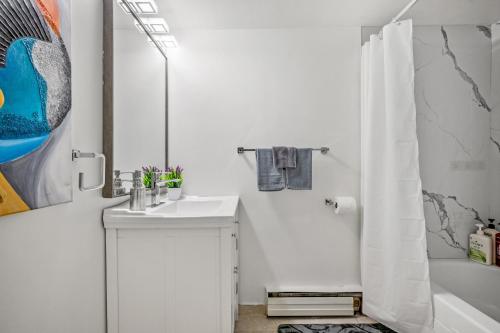 a white bathroom with a sink and a shower at 17th Ave Cozy Place in DT, short walk to Calgary Stampede in Calgary