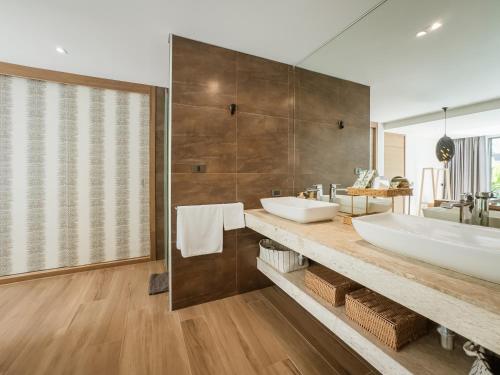 a bathroom with two sinks and a large mirror at Calypso Villa Phuket - Naiyang Beach in Nai Yang Beach