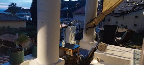 a view of a balcony with a table and a view of the city at Votre terrasse vue mer sous la vigne, un havre de paix in Ensuès-la-Redonne