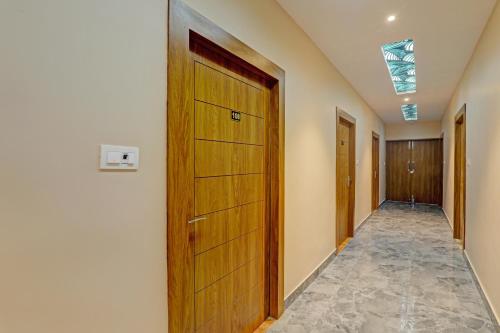 a hallway with a wooden door in a building at Hotel O Royal Regency Palace in Gorakhpur
