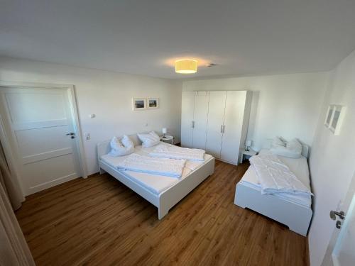 zwei Betten in einem Zimmer mit Holzboden in der Unterkunft LandschaftsTräume in Simmerath