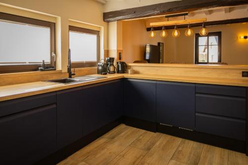 a kitchen with black cabinets and a counter top at Fank'House in Guémar