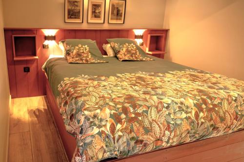a large bed in a bedroom with two pillows on it at Fank'House in Guémar