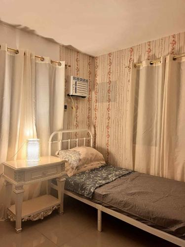 a bedroom with a bed and a table and curtains at Casa Flores in Sampong