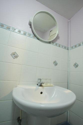 a bathroom with a white sink and a mirror at Chaba Chalet Hotel in Hua Hin