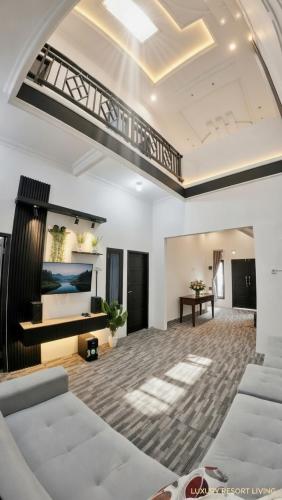 a living room with a white couch and a staircase at Altea House in Diyeng