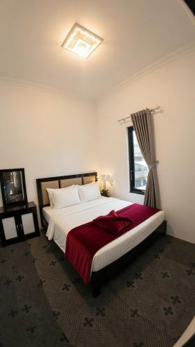 a bedroom with a large bed with a red blanket at Altea House in Diyeng