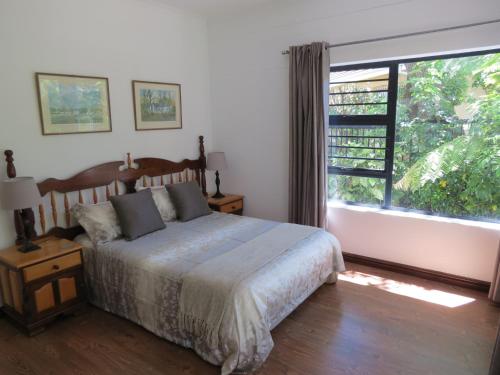 a bedroom with a bed and a large window at 10 Kommandeurs Ave, Stellenbosch in Stellenbosch