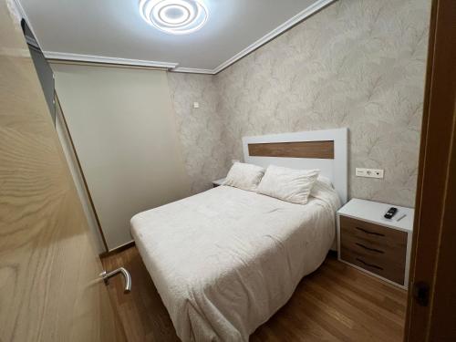 a small bedroom with a bed and a night stand at Paraiso Spa Reinante in San Miguel de Reinante