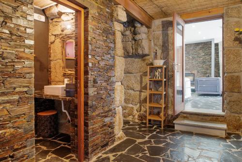 a bathroom with a stone wall and a mirror at Casa Ci in Vila Franca