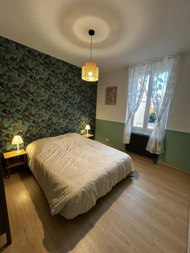 a bedroom with a bed and two tables and a window at Au papillon des coteaux in Magenta