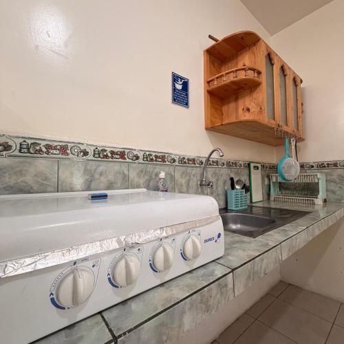 a kitchen with a sink and a stove at Casa de Huéspedes Playas Arena in Playas