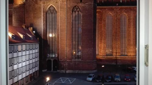 a view of a church with cars parked in a parking lot at Apartment in Old Town - view of Mariacki Church in Gdańsk
