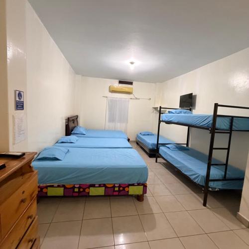a room with two bunk beds and a desk at Casa de Huéspedes Playas Arena in Playas