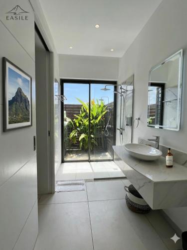 a bathroom with a sink and a large window at Villa Fontainebleau in Grand-Baie
