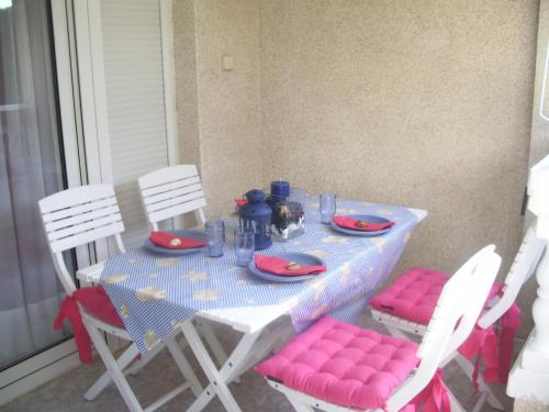 a table with pink chairs and a blue and white table cloth at Apartment Martinez Casablanca in Alcossebre