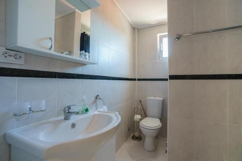 a white bathroom with a sink and a toilet at Apartment DiLen in Dobra Voda