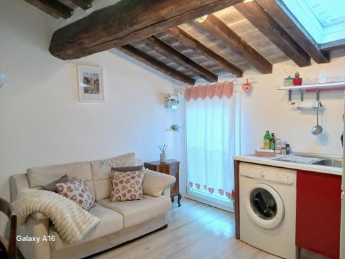 a living room with a couch and a kitchen at Appartamento in centro a Modena - Ca' Pomposa bed&relax in Modena