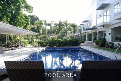 a swimming pool in front of a building at Hotel Siena in Sampong