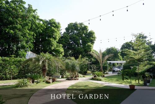 a hotel garden with trees and a sign that reads hotel garden at Hotel Siena in Sampong