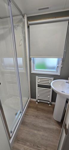 a bathroom with a shower and a sink at 8 berth 3 Bedroomed CARAVAN Lyons Robin Hood Rhyl 17 Elm Crescent in Meliden