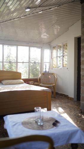 a room with two beds and a table and windows at Burj Resort in Ban