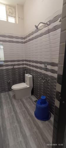 a bathroom with a toilet and a blue object at Shri Lawn Park in Sīrkāzhi